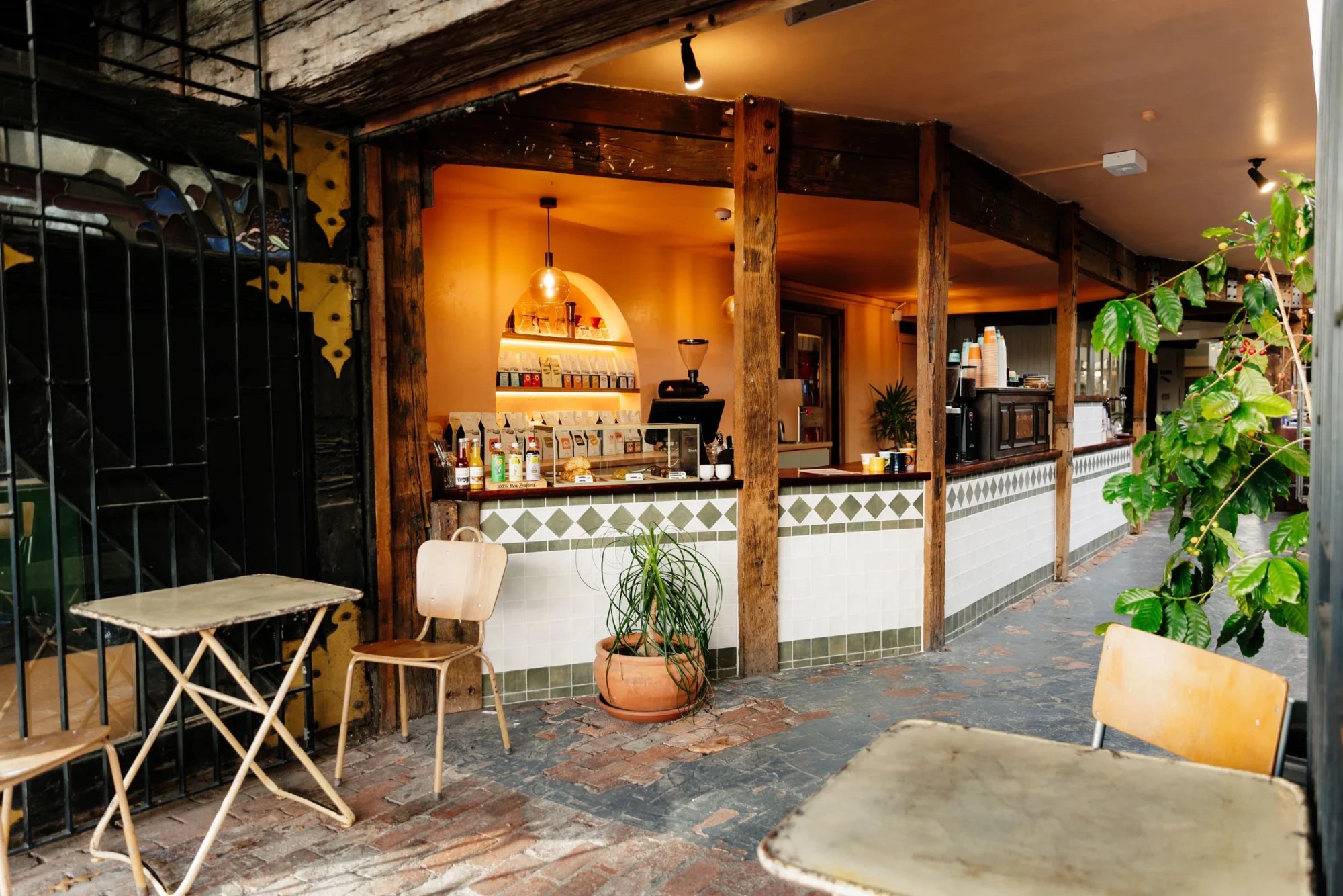 The Sublime brew bar counter in the Bridge Street Studios laneway, with tiled front, timber posts and shelves of coffee bags